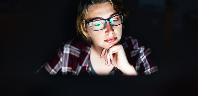 Woman looking at her computer screen smiling
