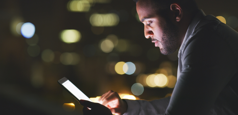 Person looking at their tablet at night