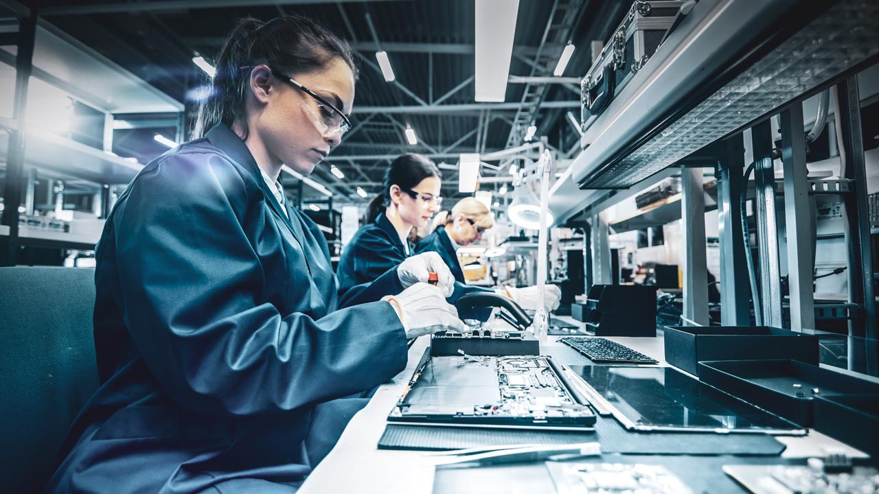 Women in protective clothing on hi tech production line