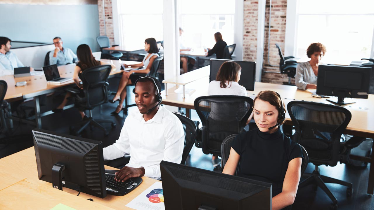 Open plan office with call centre employees in front of laptops