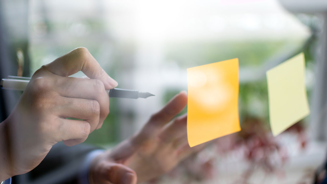 Writing on post it note on glass