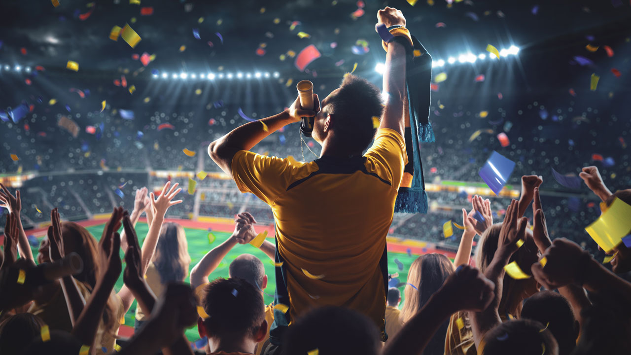 Australian rugby fan waving in a crowded stadium at night